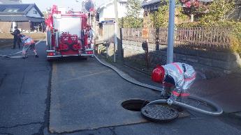 消防団による防火水槽からの取水活動